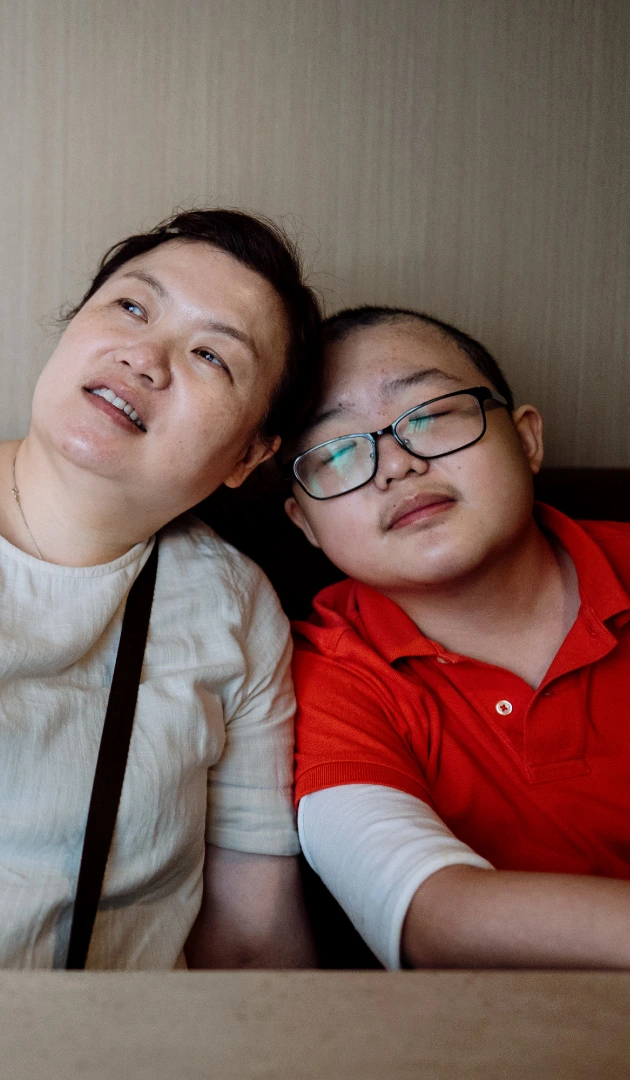 mother and son sitting and leaning against each other