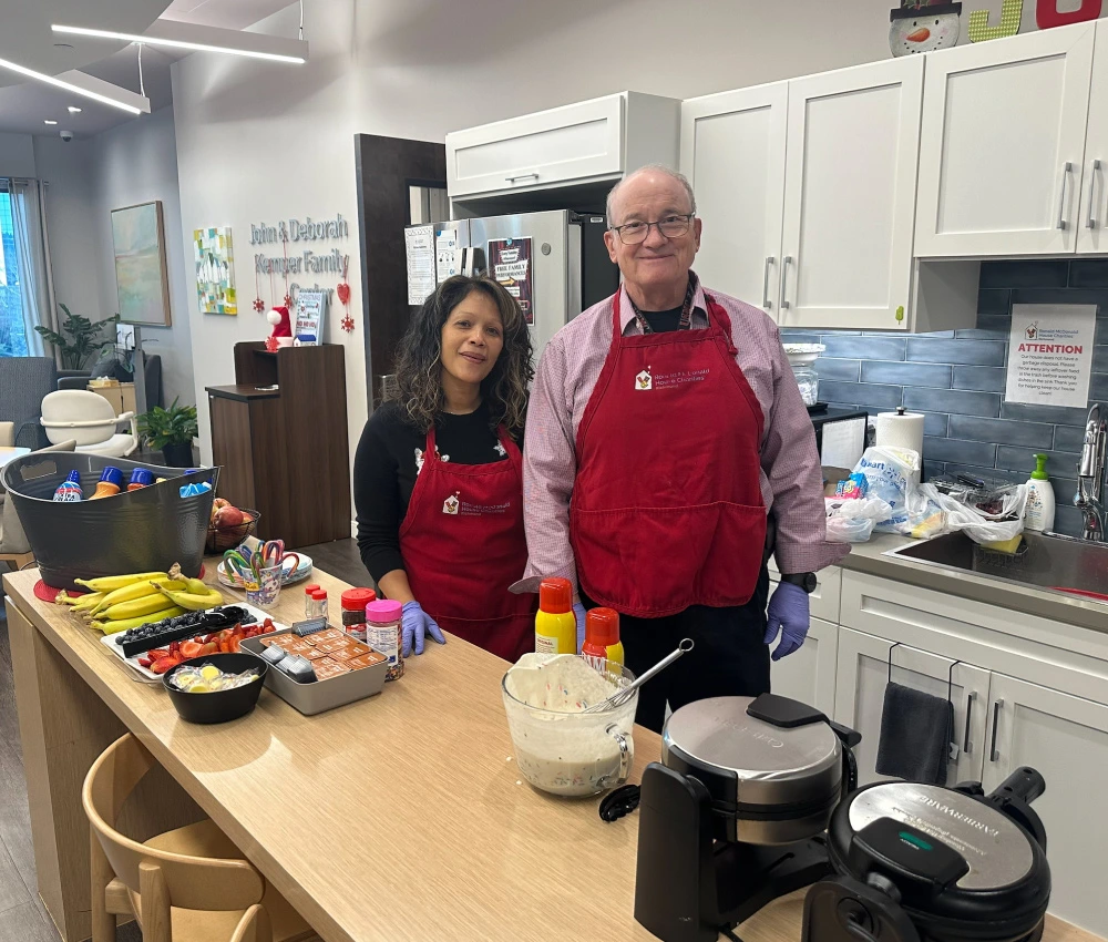 two volunteers preparing breakfast for our families