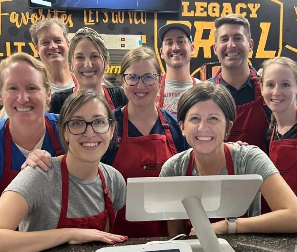 members of the red shoe crew working together all wearing matching red aprons