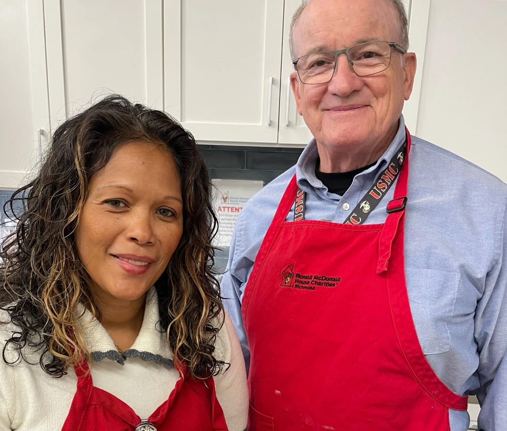 two Ronald McDonald House richmond volunteers in red aprons